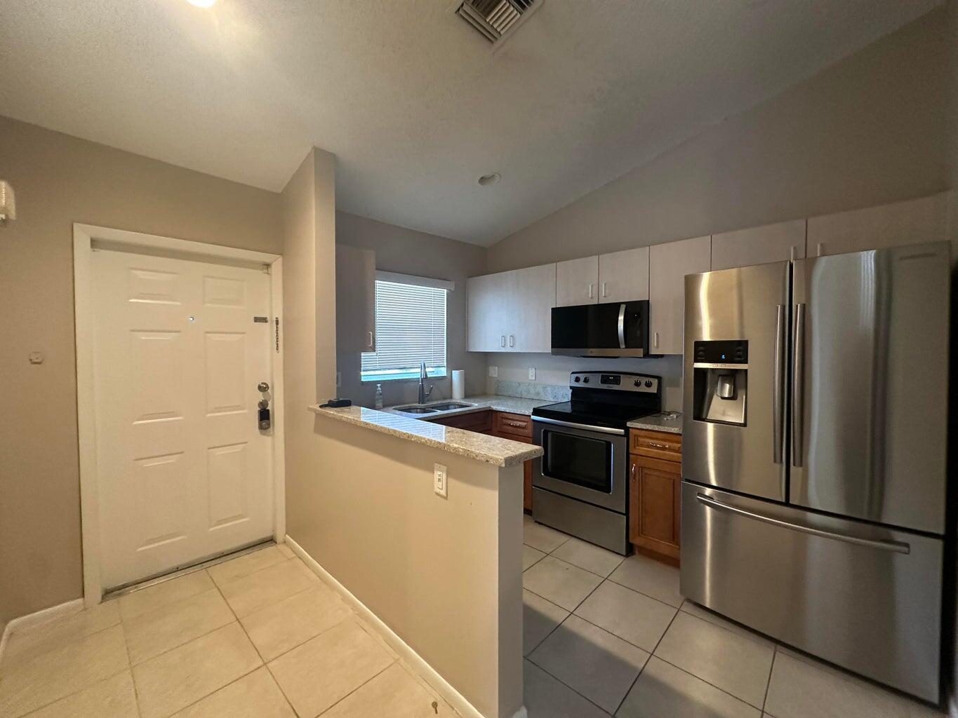 300 Northeast 42nd Street Boca Raton, FL 33431 - Photo 21 of 53 a kitchen with stainless steel appliances granite countertop a refrigerator and a stove top oven