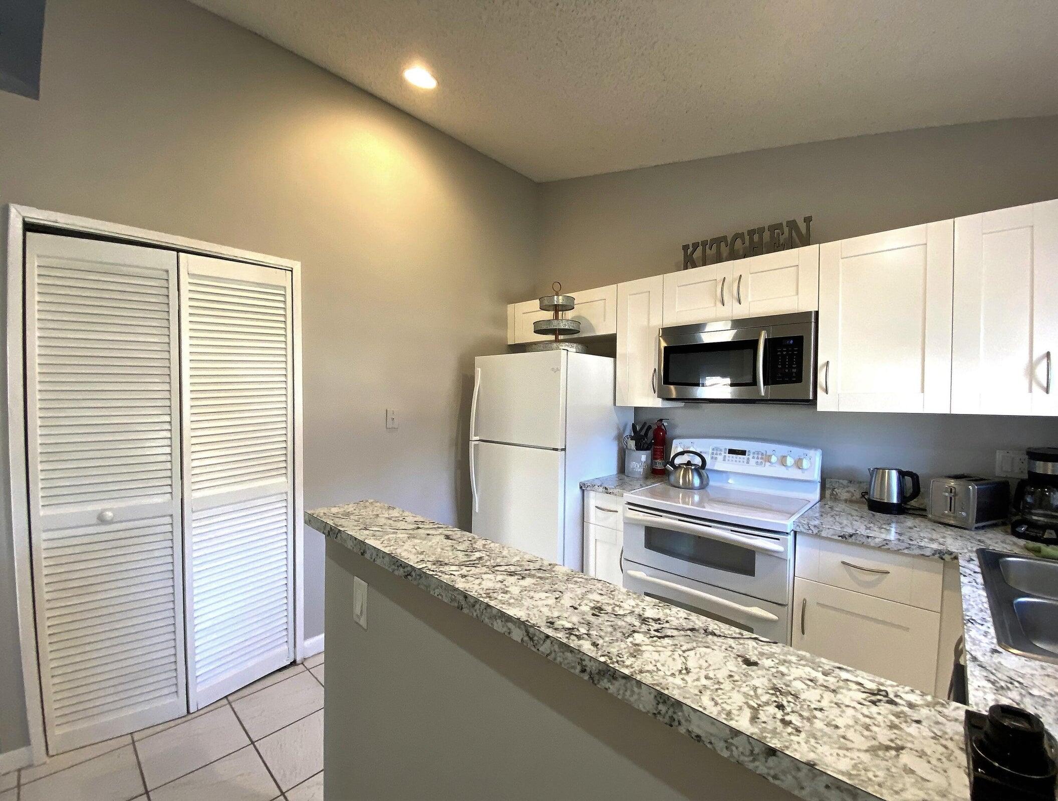 300 Northeast 42nd Street Boca Raton, FL 33431 - Photo 29 of 53 a kitchen with stainless steel appliances granite countertop a sink stove and refrigerator