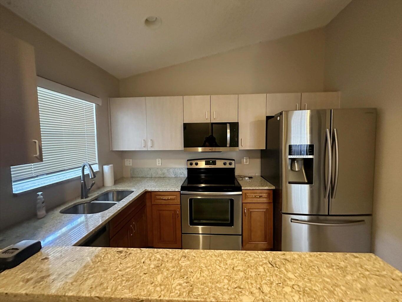 300 Northeast 42nd Street Boca Raton, FL 33431 - Photo 3 of 53 a kitchen with a refrigerator stove and sink