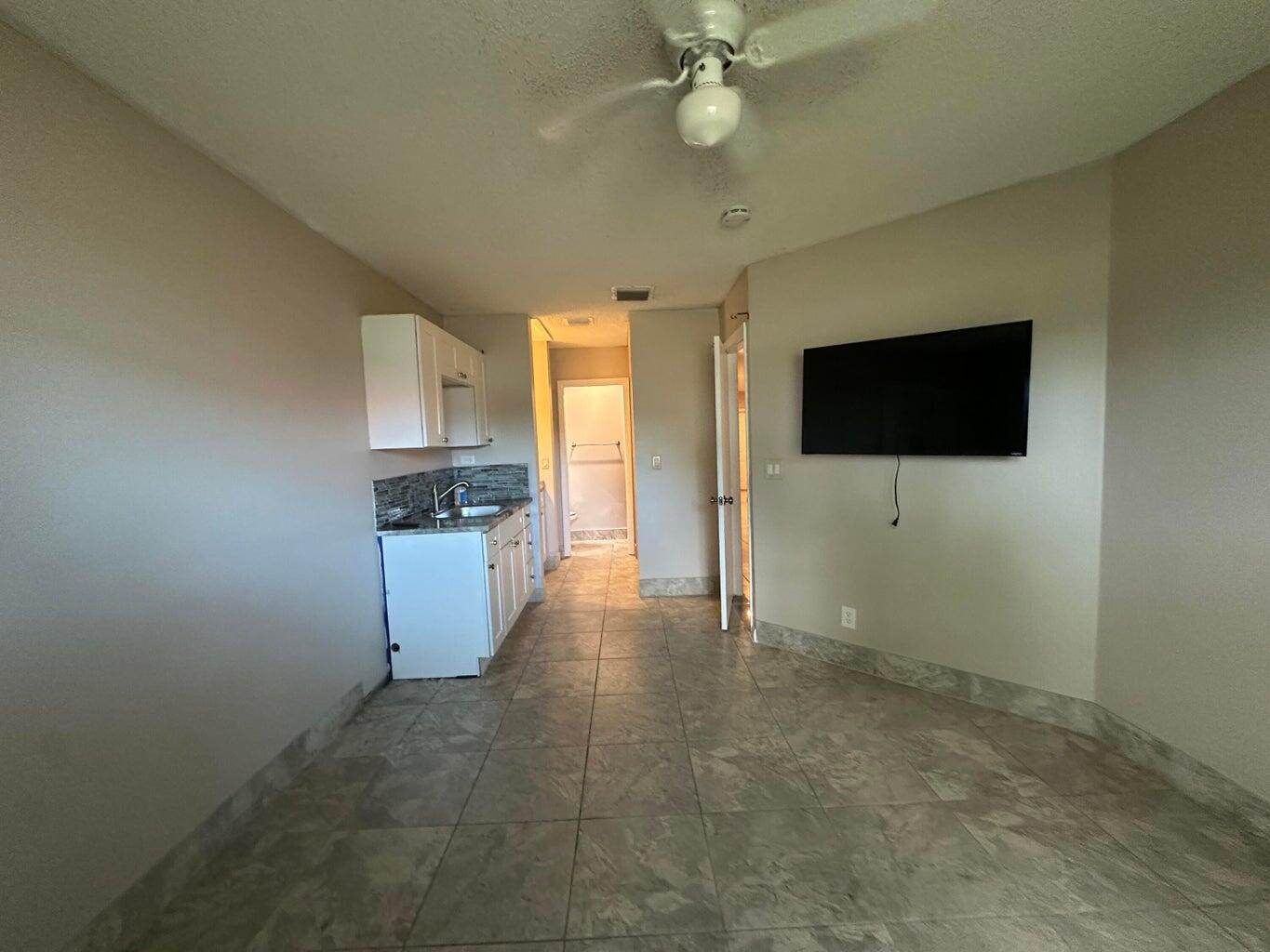 300 Northeast 42nd Street Boca Raton, FL 33431 - Photo 7 of 53 a view of a kitchen with a sink cabinet a microwave and refrigerator