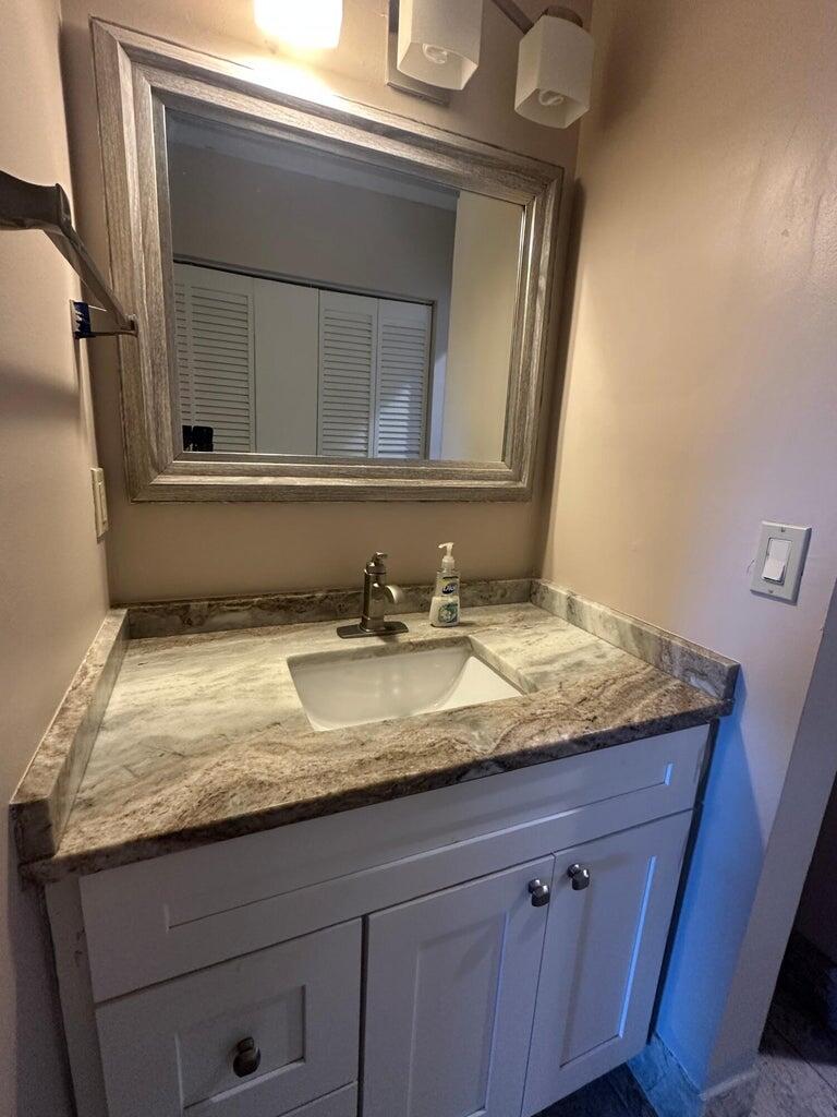 300 Northeast 42nd Street Boca Raton, FL 33431 - Photo 9 of 53 a bathroom with a granite countertop sink and a mirror