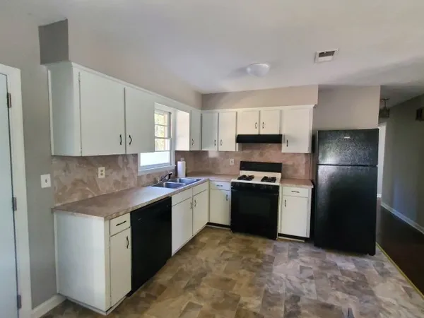 a kitchen with stainless steel appliances granite countertop a stove a refrigerator and a sink