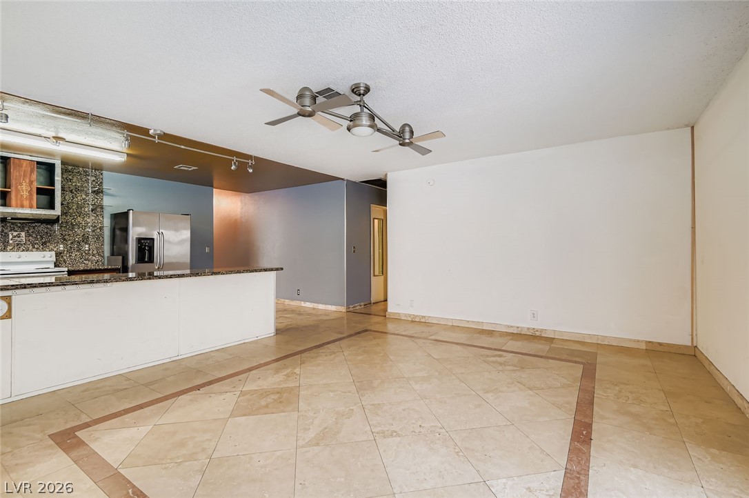 4723 Desert Vista Road Las Vegas, NV 89121 - Photo 13 of 29 Family room with inlaid floor details, ceiling fan, a textured ceiling, and light tile patterned floors