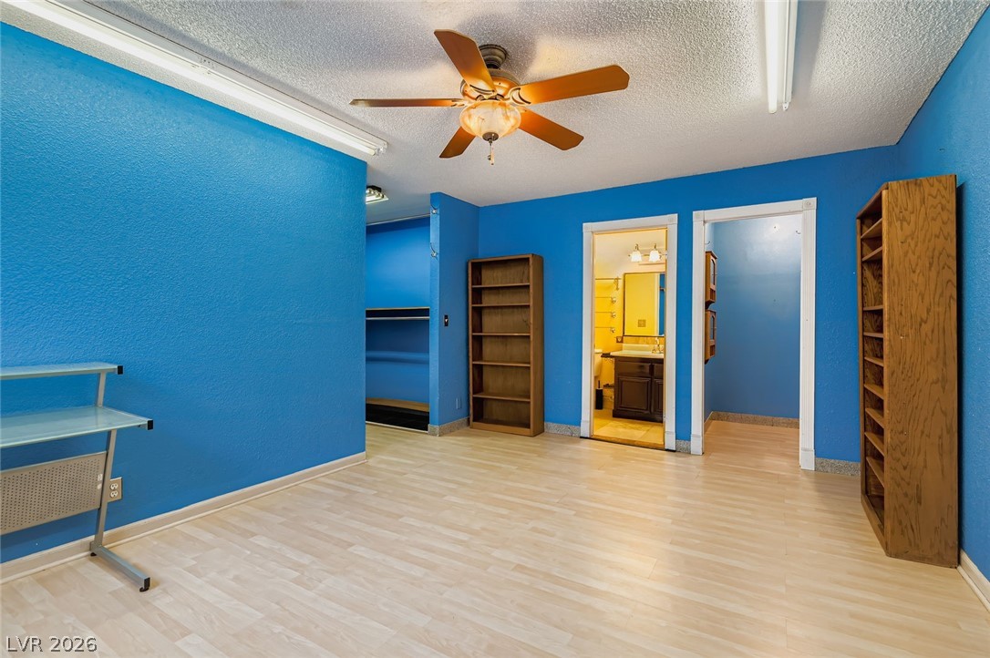 4723 Desert Vista Road Las Vegas, NV 89121 - Photo 15 of 29 Primary bedroom with a textured ceiling, wood finished floors, a spacious closet, ceiling fan, and ensuite bathroom