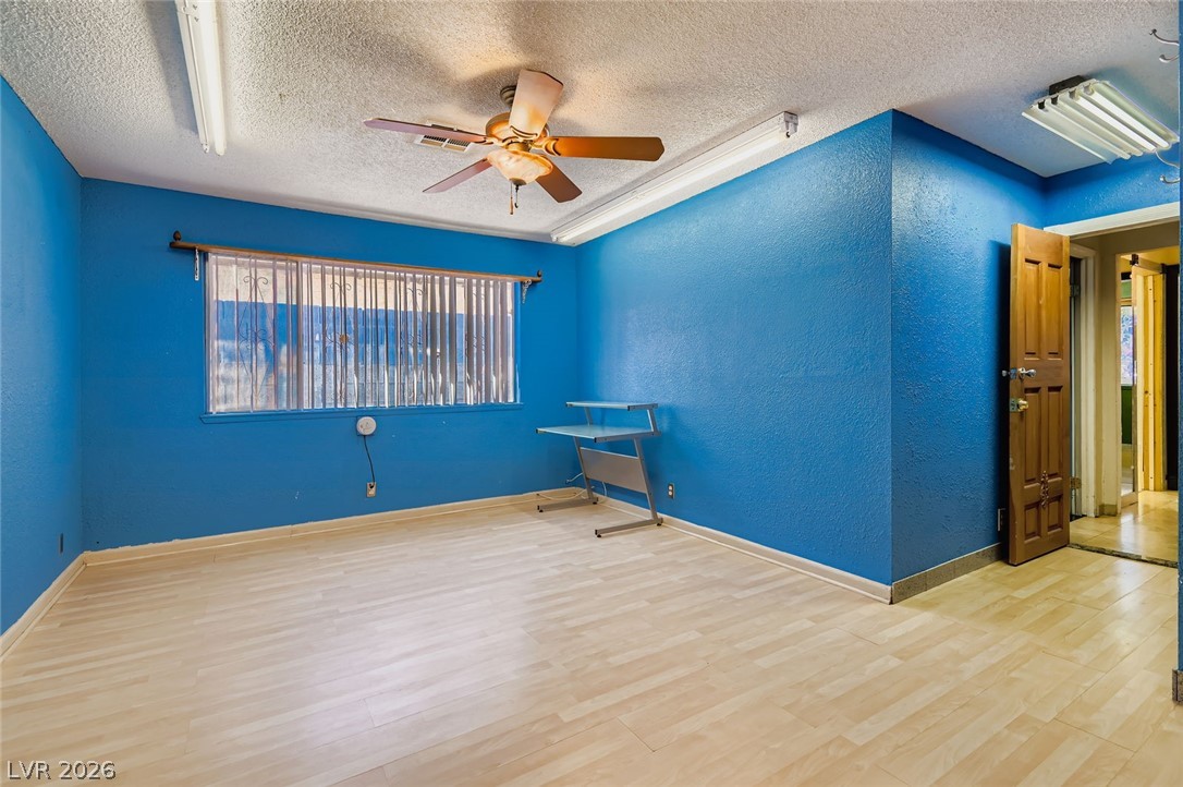 4723 Desert Vista Road Las Vegas, NV 89121 - Photo 16 of 29 Primary room with a textured ceiling, a ceiling fan, wood finished floors, and a textured wall
