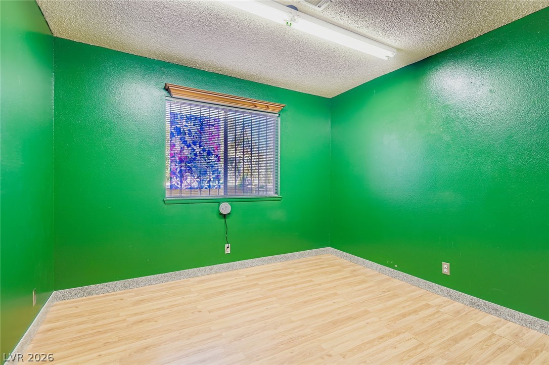 4723 Desert Vista Road Las Vegas, NV 89121 - Photo 23 of 29 Unfurnished room featuring a textured ceiling and wood finished floors