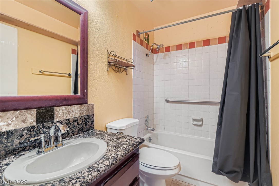 4723 Desert Vista Road Las Vegas, NV 89121 - Photo 25 of 29 Bathroom featuring shower / bath combo, backsplash, vanity, and a textured wall