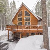 a view of a house with wooden deck and snow