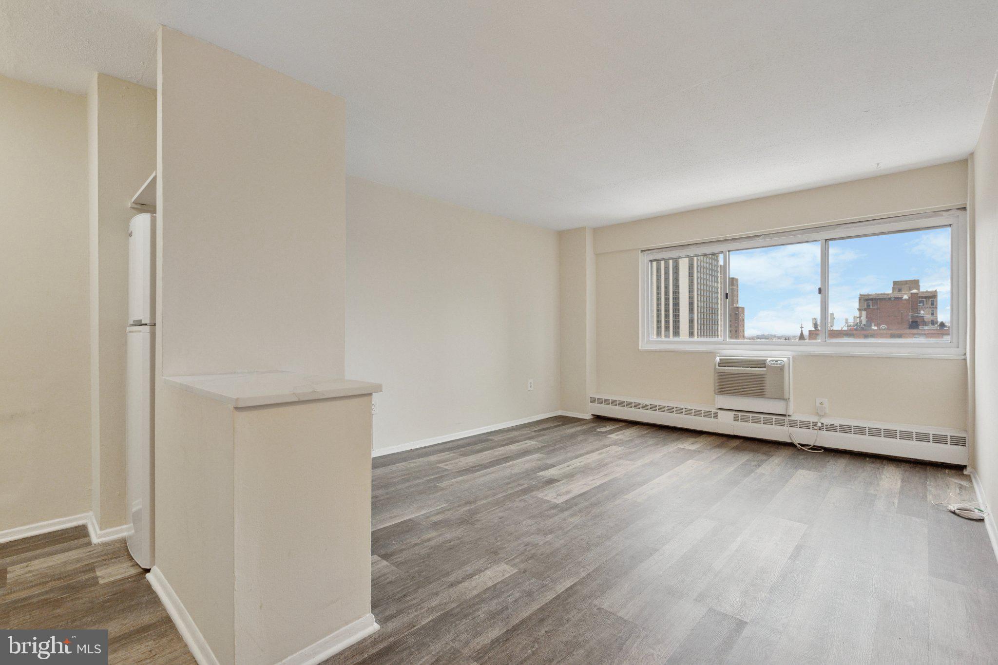 2101 Chestnut Street, Unit 1610 Philadelphia, PA 19103 - Photo 1 of 15 a view of an empty room with a window and wooden floor