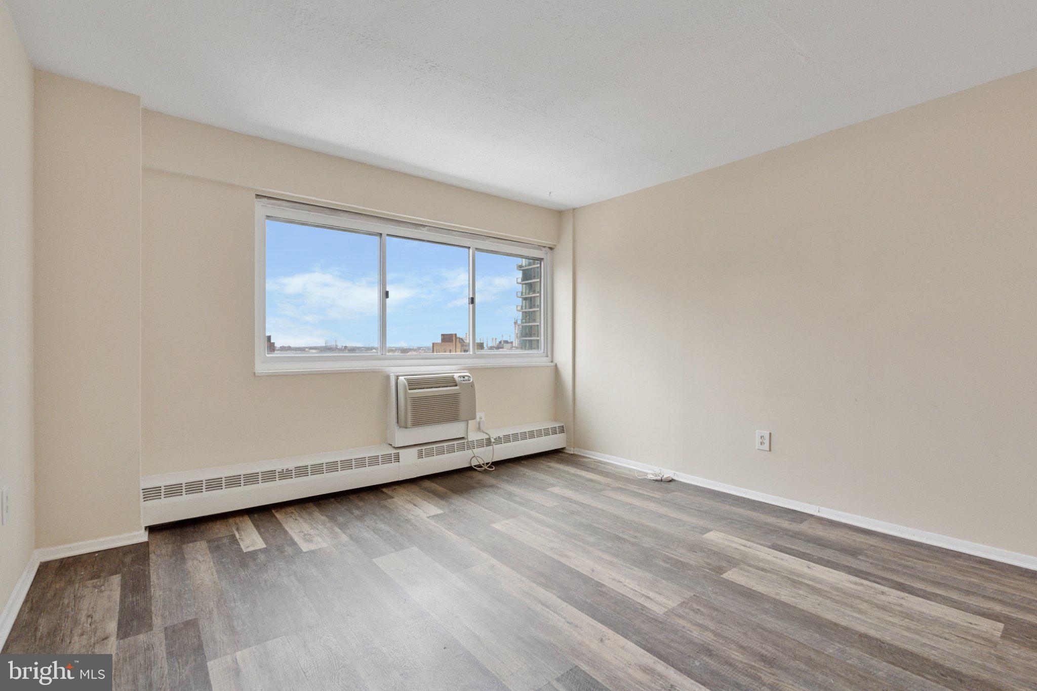 2101 Chestnut Street, Unit 1610 Philadelphia, PA 19103 - Photo 4 of 15 a view of an empty room with wooden floor and a window