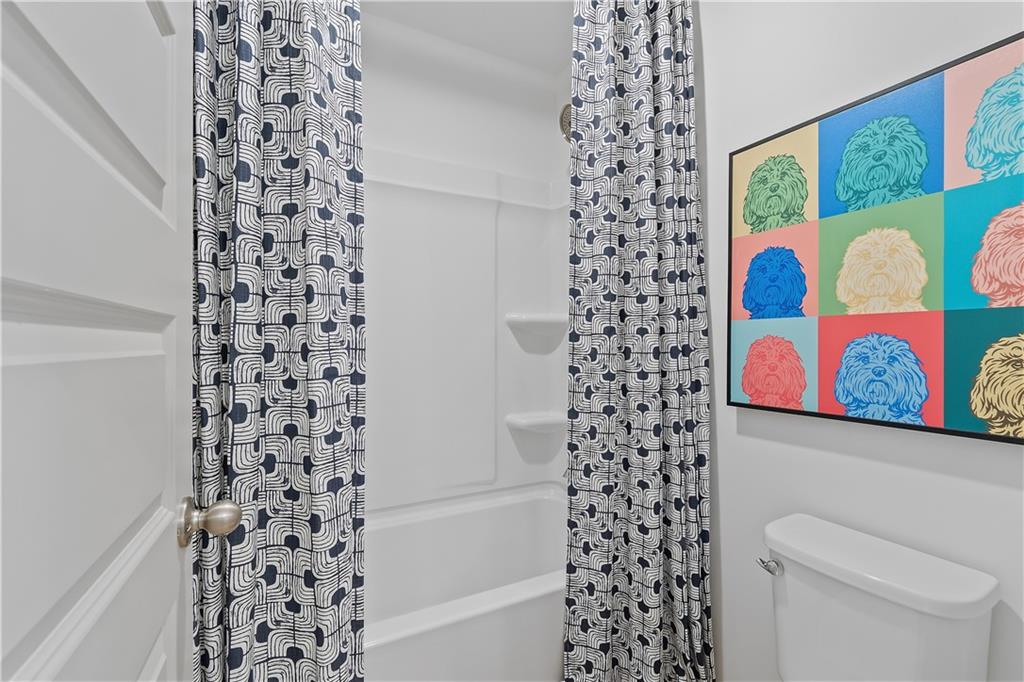 157 Haverling Pass Atlanta, GA 30349 - Photo 31 of 45 a bathroom with a toilet and a shower curtain