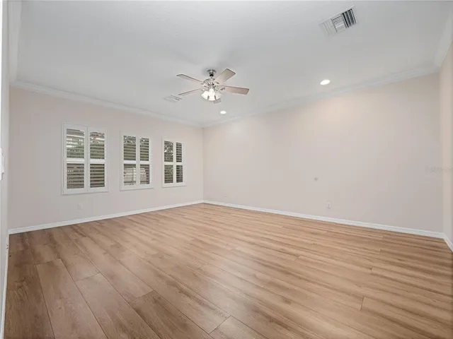 a view of an empty room with a window and wooden floor