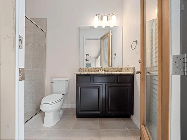 a bathroom with a granite countertop sink a toilet and a mirror