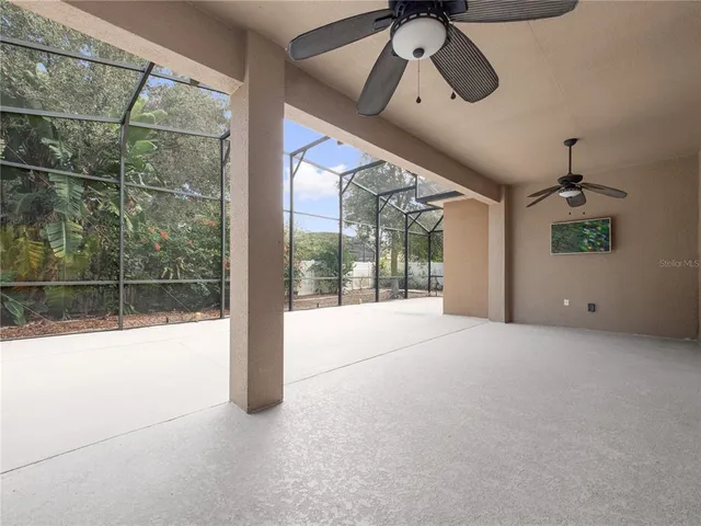 a view of a room with a ceiling fan and window