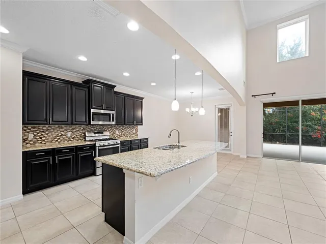 a large kitchen with stainless steel appliances granite countertop a large counter top and a stove top oven