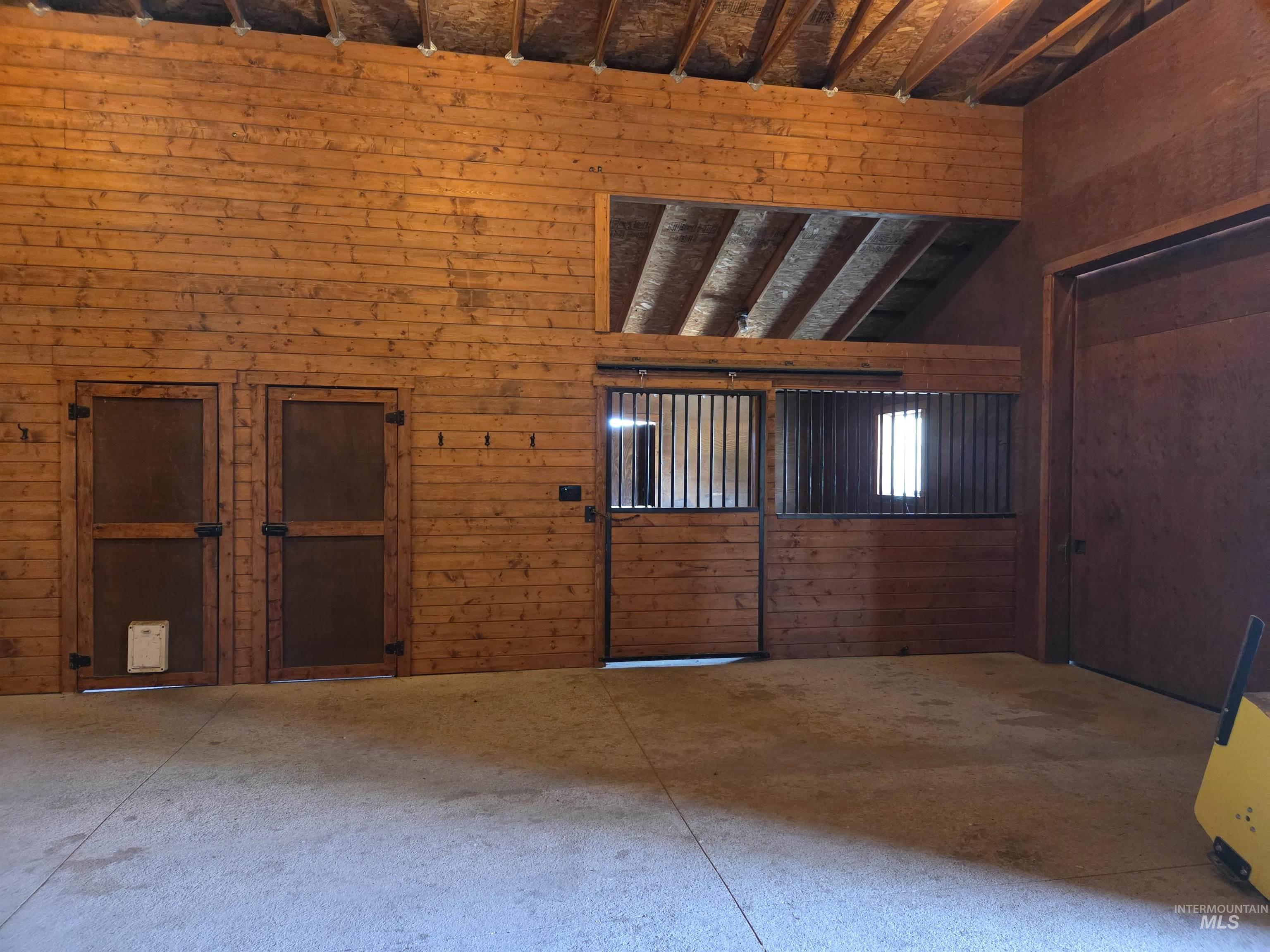 1085 Wallen Road Moscow, ID 83843 - Photo 39 of 50 Interior space featuring wood plank walls, exposed beam ceiling structure, and concrete flooring