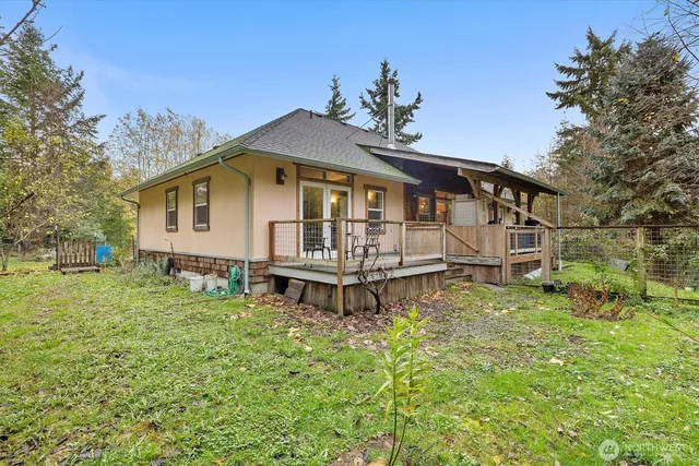 a white house that has a small yard and a wooden fence