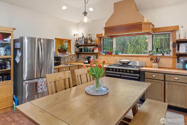 a kitchen with stainless steel appliances a dining table and chairs