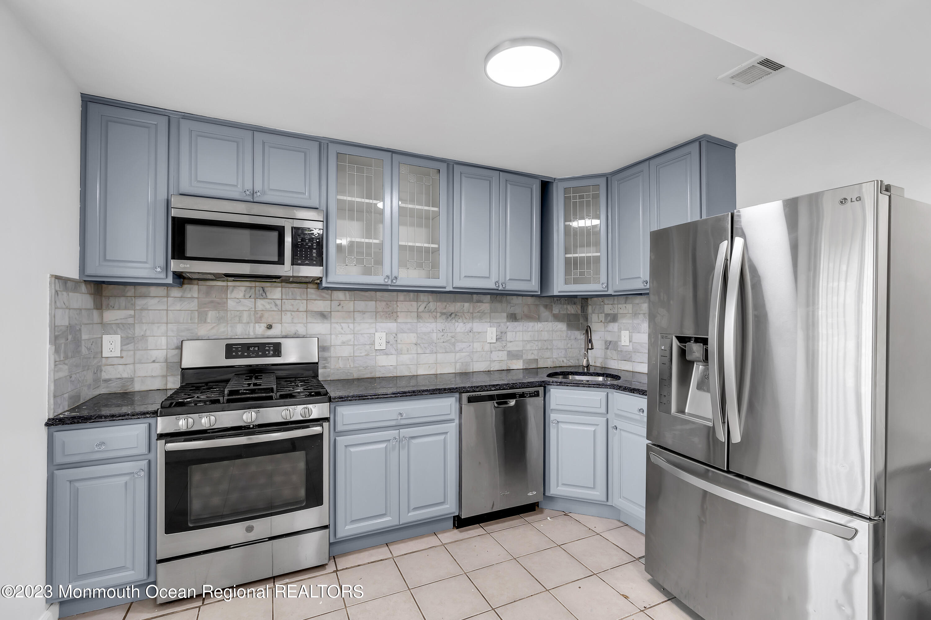 a kitchen with cabinets stainless steel appliances and a counter space