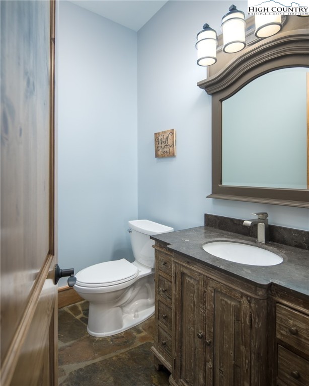 708 Goldenrod Road Boone, NC 28607 - Photo 34 of 49 a bathroom with a granite countertop toilet a sink and a mirror