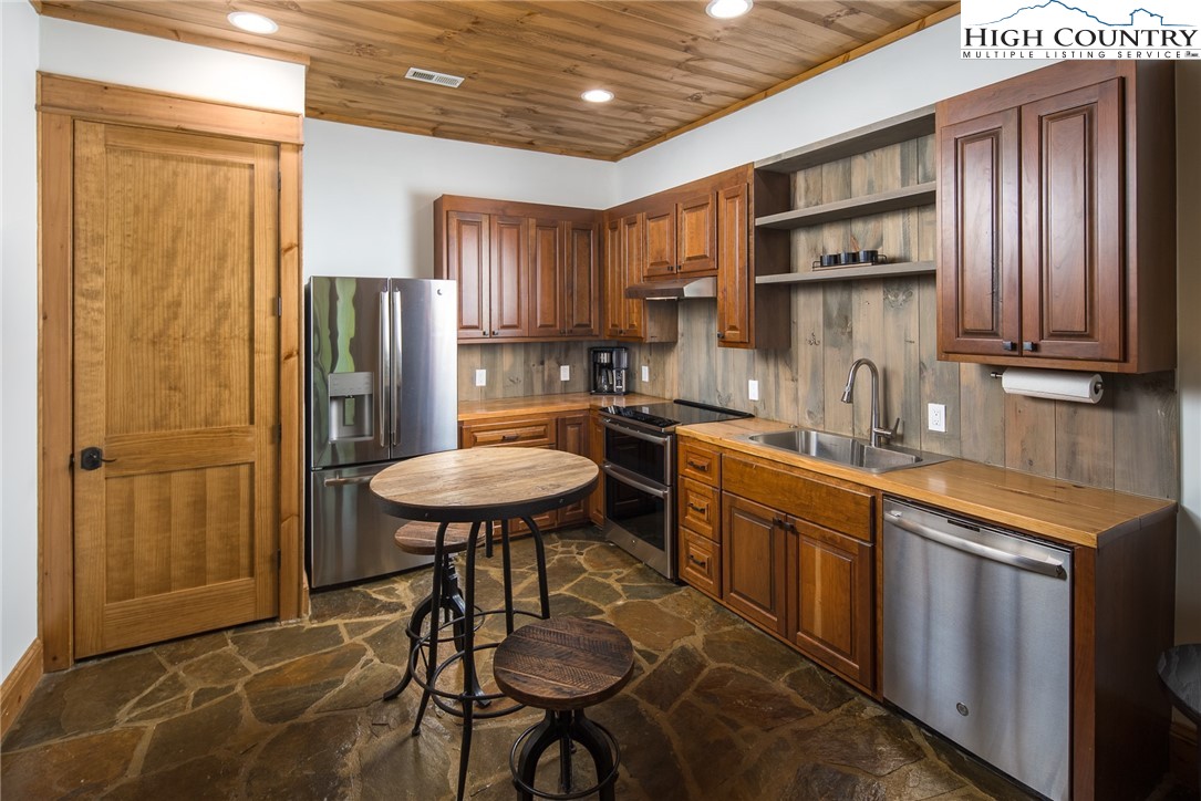 708 Goldenrod Road Boone, NC 28607 - Photo 39 of 49 a kitchen with stainless steel appliances a dining table chairs refrigerator and sink