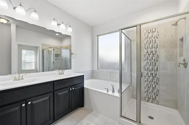 a bathroom with a tub sink shower and mirror
