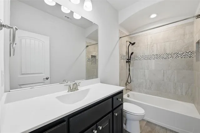 a bathroom with a sink a toilet a mirror and shower