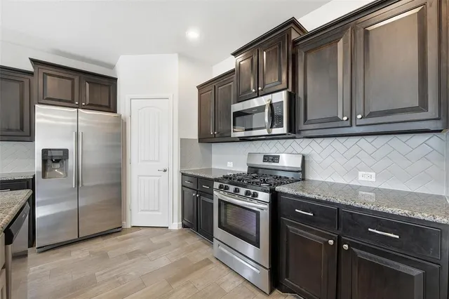 a kitchen with granite countertop wooden cabinets stainless steel appliances and a granite counter tops