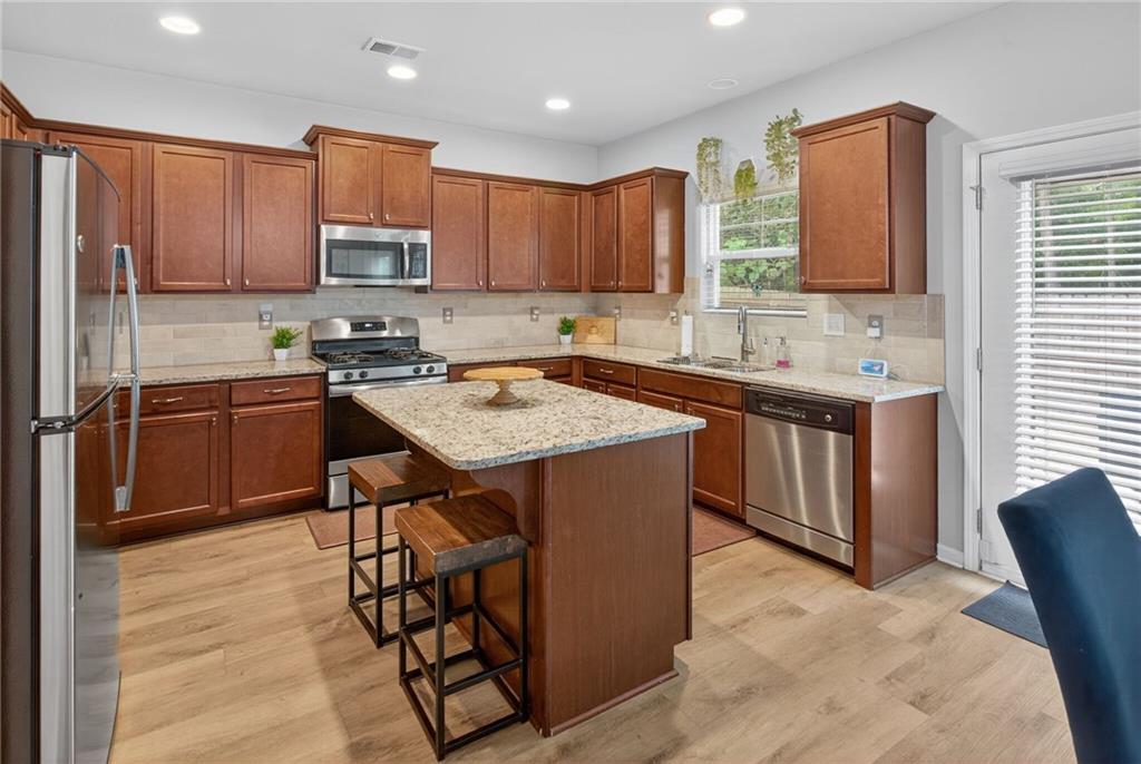 3333 Cascade Parc Boulevard Southwest Atlanta, GA 30311 - Photo 7 of 21 a kitchen with stainless steel appliances granite countertop a table chairs sink refrigerator and cabinets