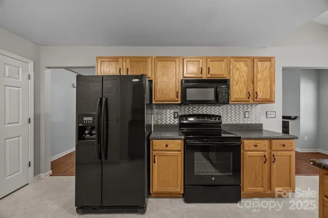 a kitchen with a refrigerator and a stove top oven