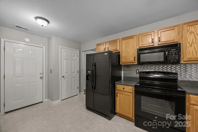 a kitchen with stainless steel appliances a stove a microwave and a hard wood floor
