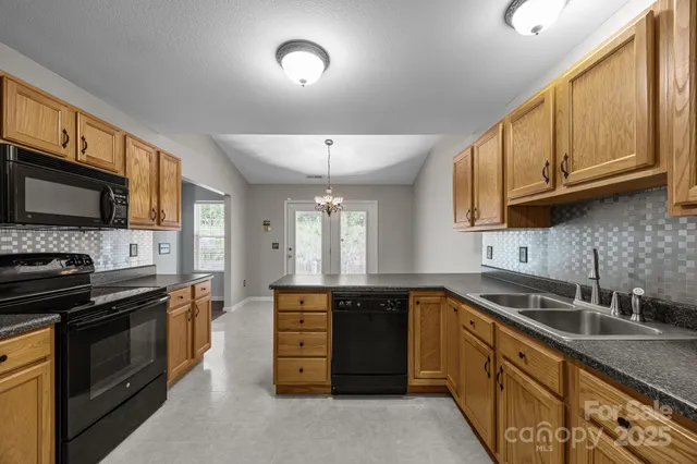 a kitchen with stainless steel appliances granite countertop a sink stove and microwave