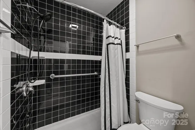 a bathroom with a toilet and a shower