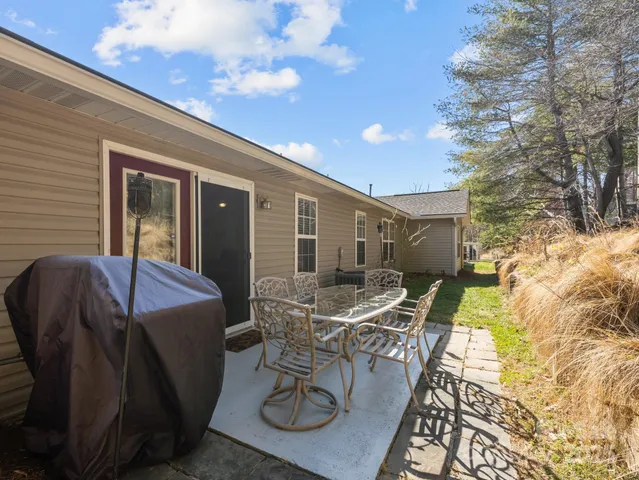 a view of a patio with table and chairs with wooden floor and fence