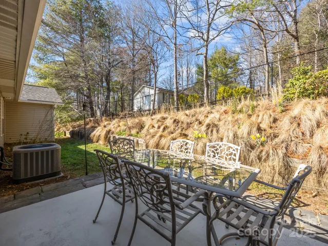 a view of a patio with table and chairs with wooden fence and plants