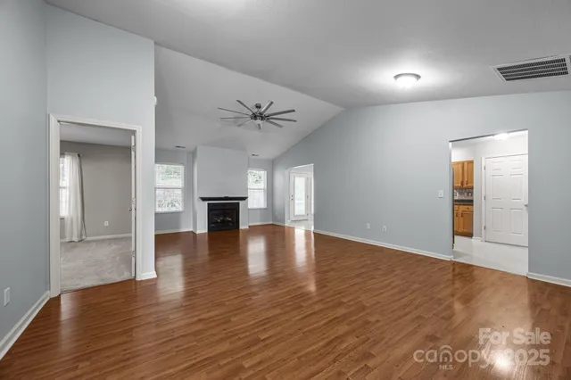 a view of empty room with wooden floor and fireplace