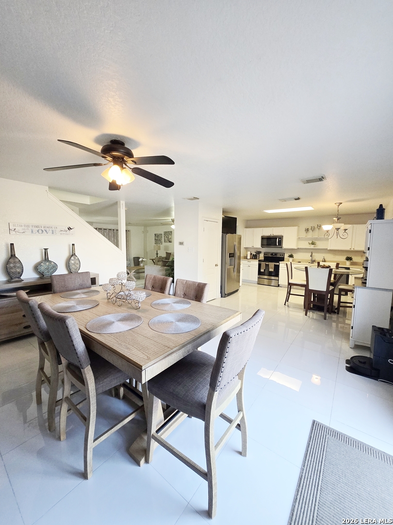 6606 Highland Grass Converse, TX 78109 - Photo 6 of 27 a dining hall with stainless steel appliances kitchen island granite countertop a table and chairs in it