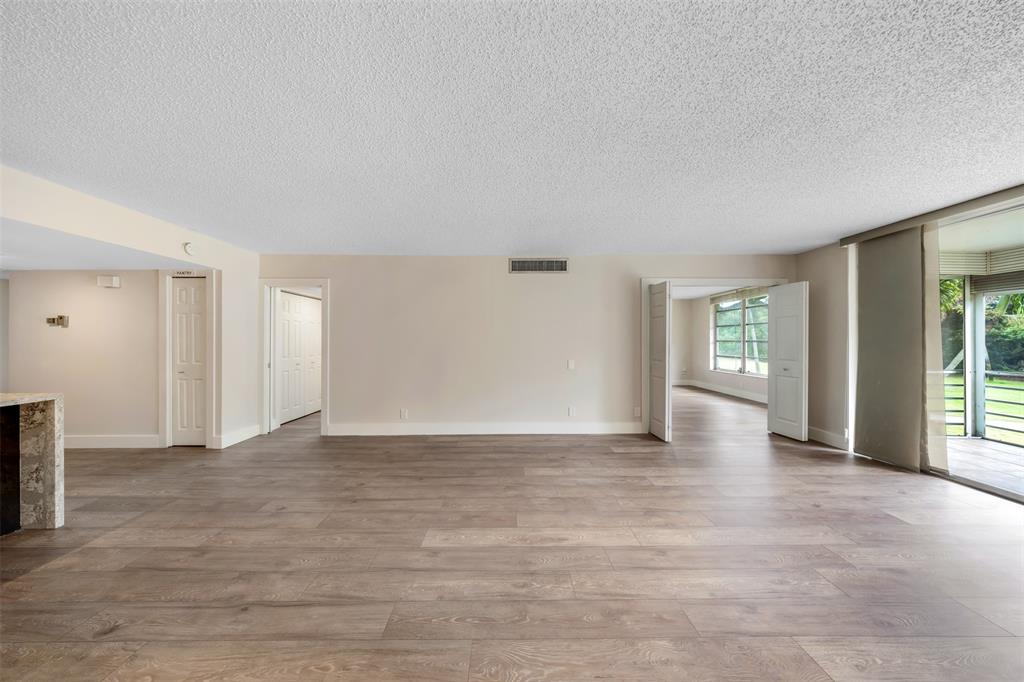 800 East Cypress Lane, Unit 206 Pompano Beach, FL 33069 - Photo 11 of 33 a view of an empty room with window and wooden floor