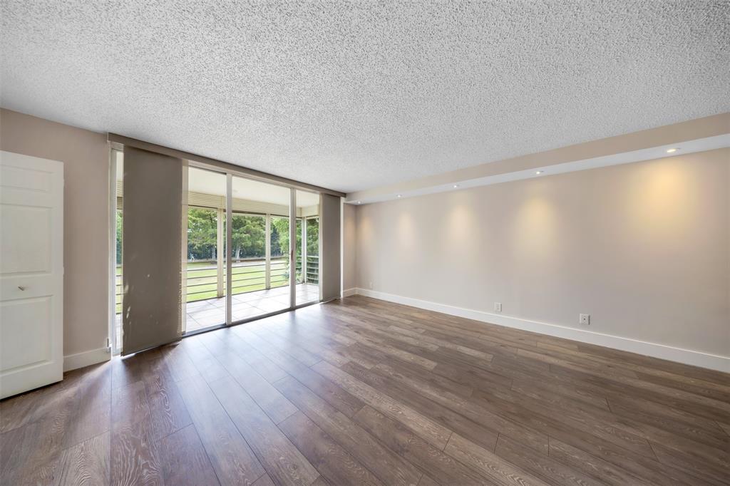 800 East Cypress Lane, Unit 206 Pompano Beach, FL 33069 - Photo 14 of 33 a view of an empty room with wooden floor and a window