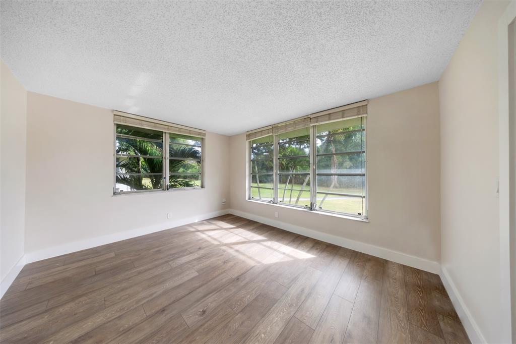 800 East Cypress Lane, Unit 206 Pompano Beach, FL 33069 - Photo 16 of 33 a view of an empty room with wooden floor and windows