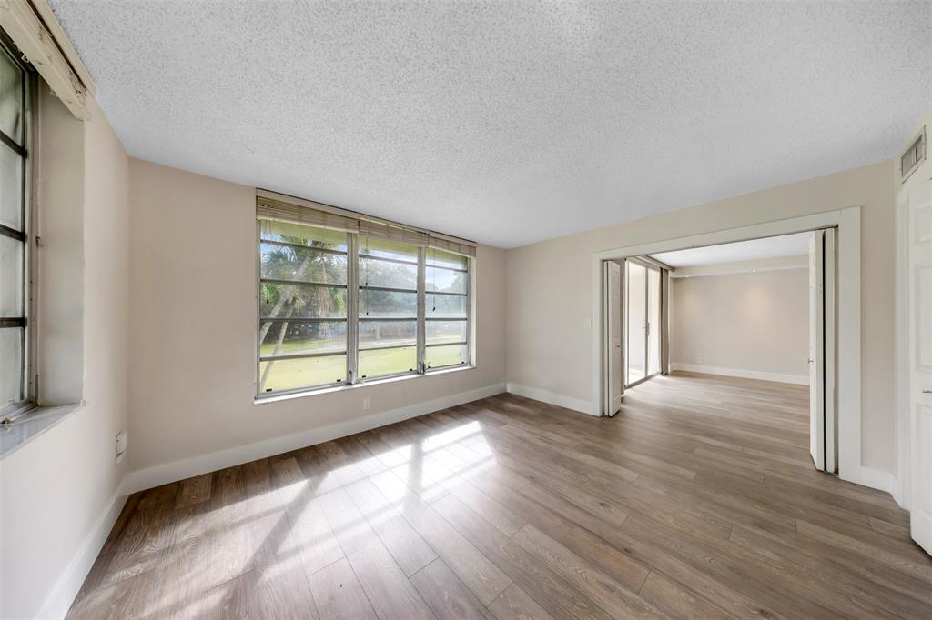 800 East Cypress Lane, Unit 206 Pompano Beach, FL 33069 - Photo 17 of 33 a view of an empty room with wooden floor and a window