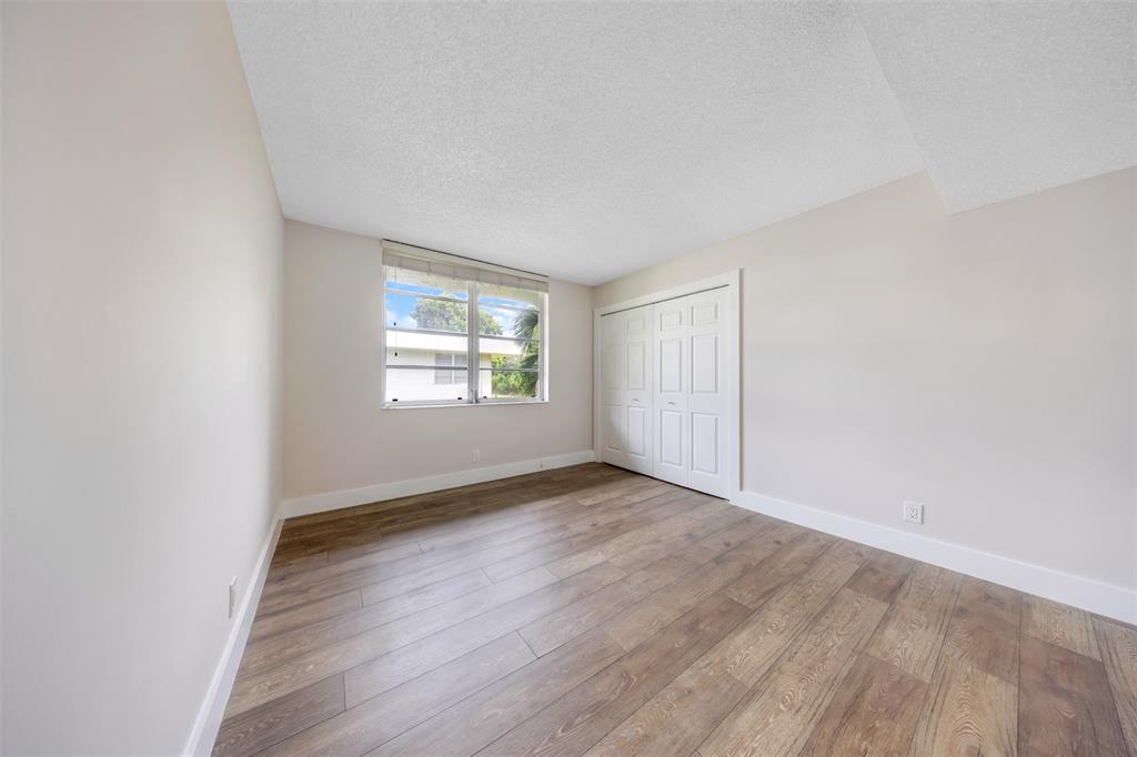 800 East Cypress Lane, Unit 206 Pompano Beach, FL 33069 - Photo 20 of 33 an empty room with wooden floor and windows