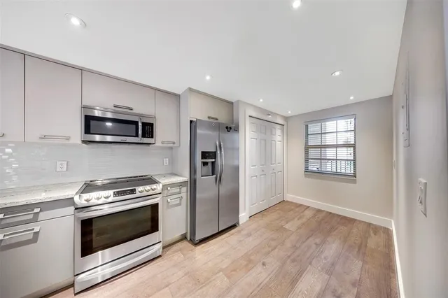 a kitchen with stainless steel appliances a stove a microwave and white cabinets