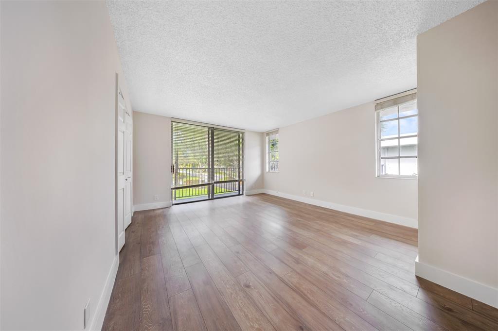 800 East Cypress Lane, Unit 206 Pompano Beach, FL 33069 - Photo 23 of 33 an empty room with wooden floor and windows
