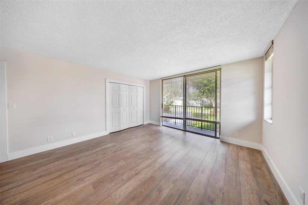 800 East Cypress Lane, Unit 206 Pompano Beach, FL 33069 - Photo 27 of 33 a view of an empty room with wooden floor and a window