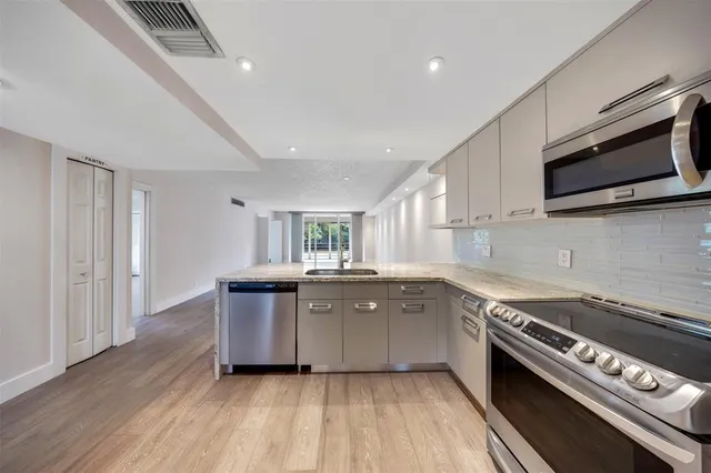 a kitchen with a sink and steel appliances