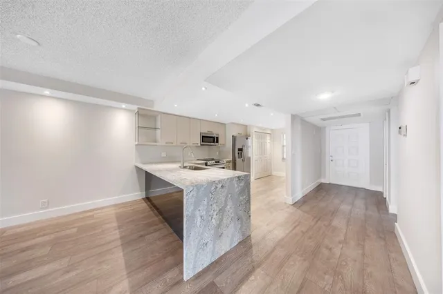 a kitchen with a sink cabinets and wooden floor