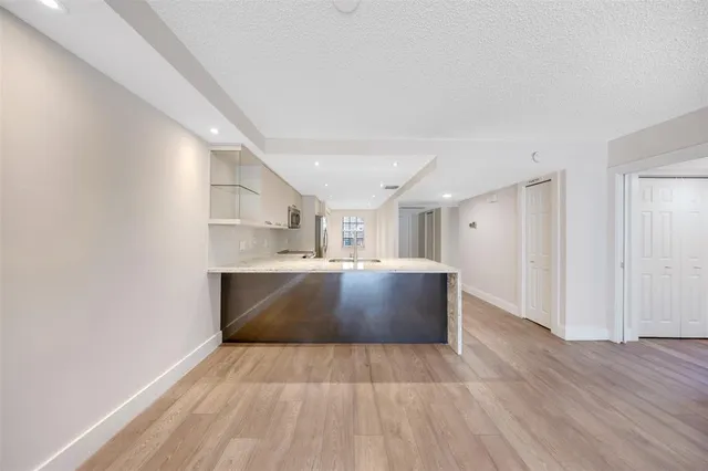 a view of kitchen and hall with wooden floor