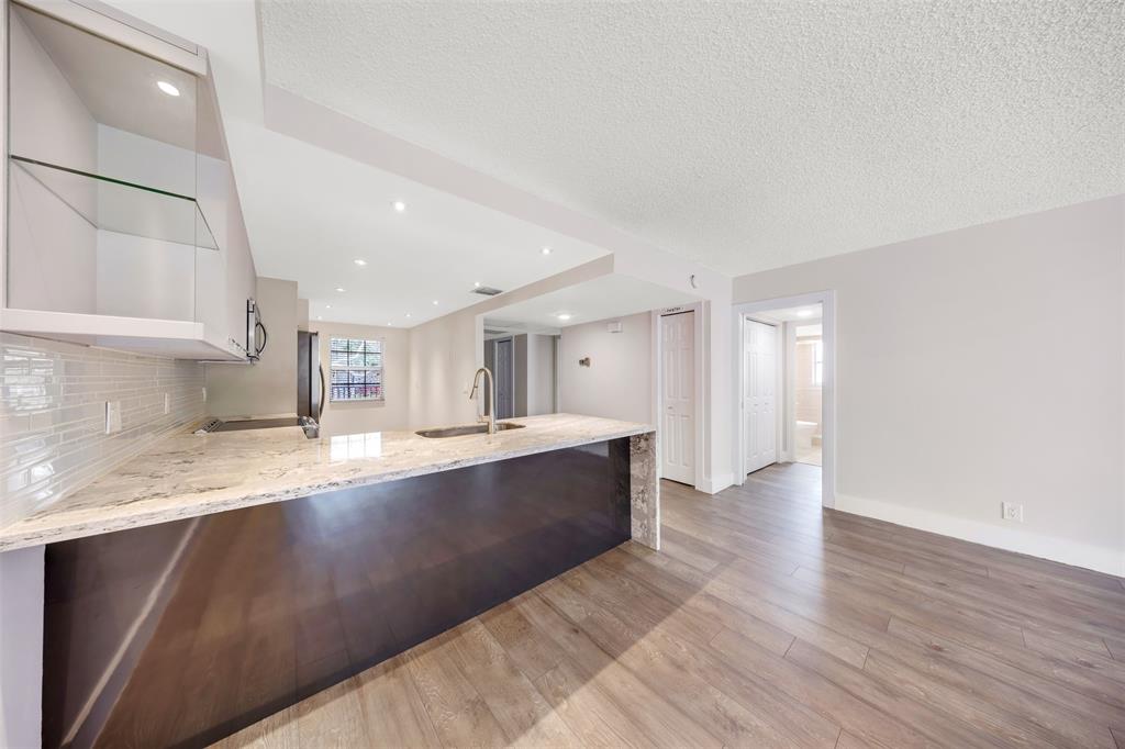 800 East Cypress Lane, Unit 206 Pompano Beach, FL 33069 - Photo 9 of 33 a large kitchen with stainless steel appliances a large counter top a sink and a granite counter tops