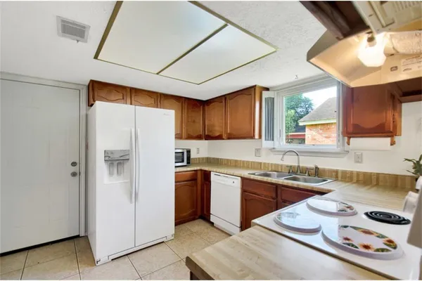 a kitchen with stainless steel appliances granite countertop a sink a stove a refrigerator and island